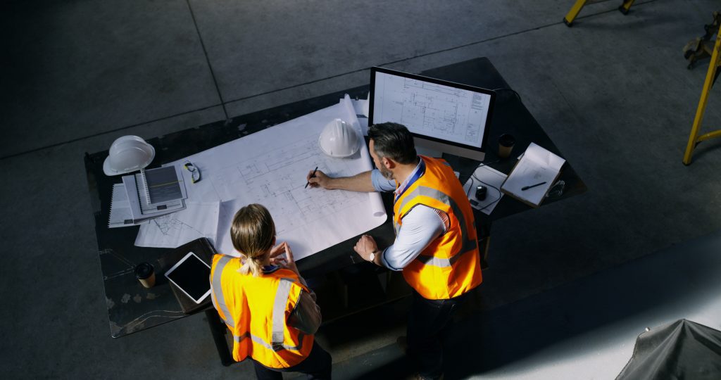Manufacturing workers creating blueprints