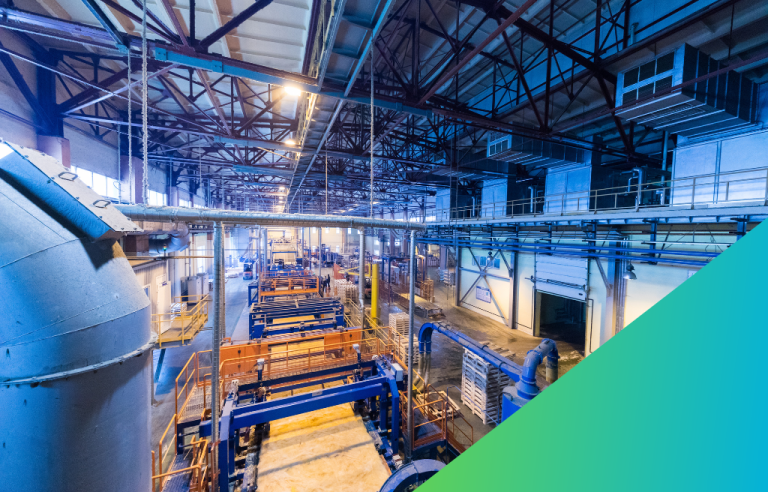 A large industrial factory floor with automated machinery, conveyors, and exposed structural steel.
