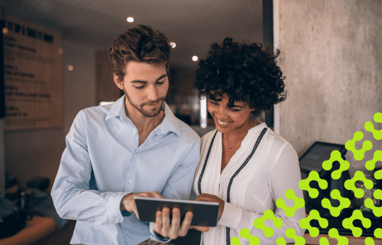 Man and woman in business attire sharing a tablet