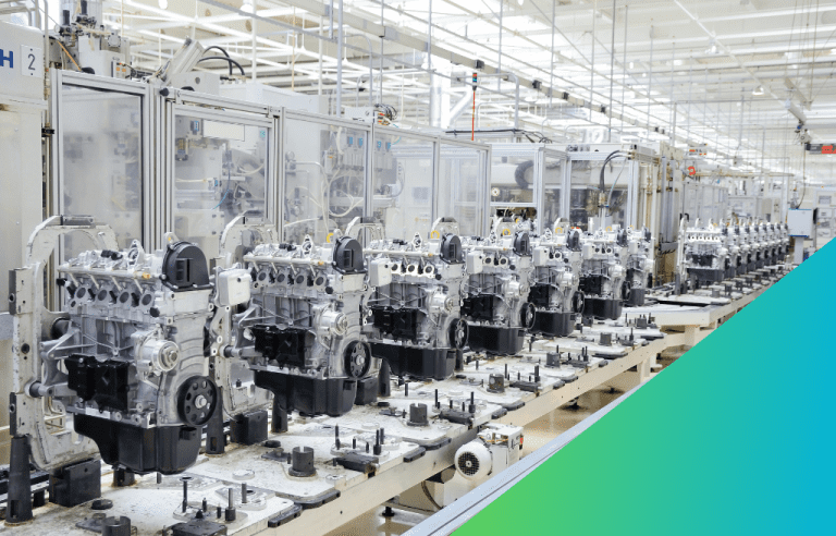 A row of vehicle engines are on a production line in a clean, modern automobile factory.