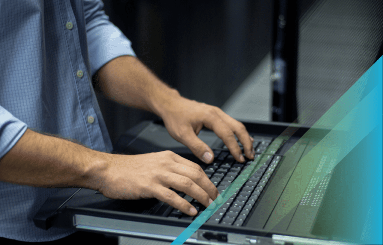 Close-up of hands typing on a laptop keyboard.