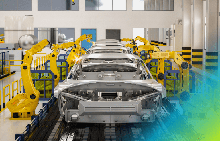 Car bodies on a production line in an automobile factory, surrounded by several yellow industrial robotic arms.