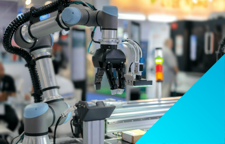 A close-up of a gray and light blue collaborative robotic arm (cobot) with a black gripper end-effector on a factory floor.