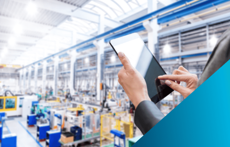 Close-up of a woman's hands using a tablet with a blurred automated factory floor and production line in the background.